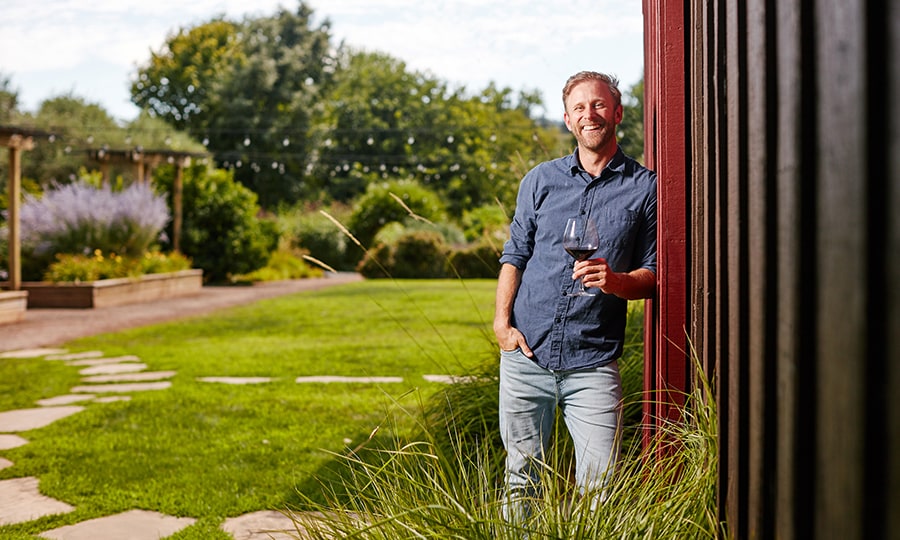 Ross Reedy, Cape House Winemaker, outdoors with a glass of wine